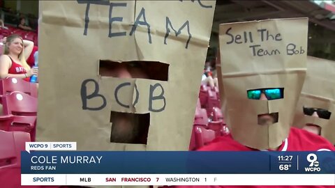 Reds fans wear paper bags over their heads saying, 'Sell the team Bob'