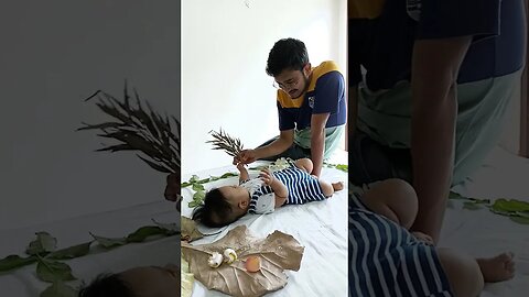 4 months old baby playing with dried leaf