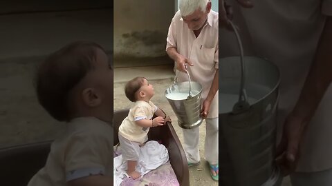 Cute beby drinking milk from big jar