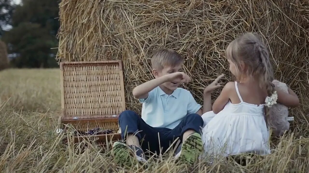 The boy and the girl are playing fun soft toy bears. A girl in a white dress. Sunset