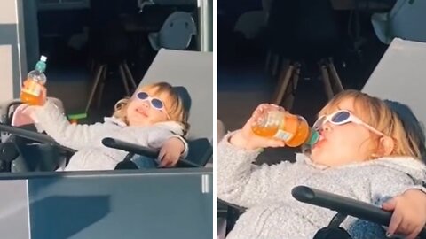 Cool kid lives her best life drinking juice in the sun