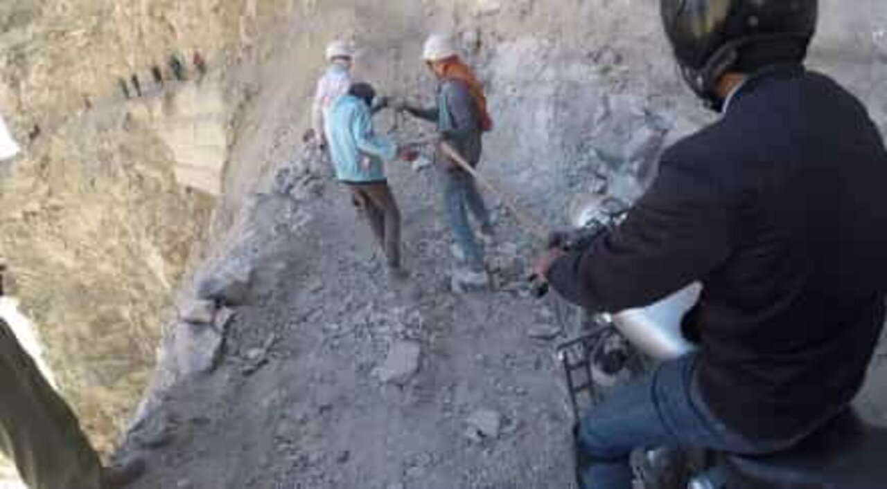 위험을 뒤로하고 히말리아 산악 길을 타는 모터사이클 라이더들