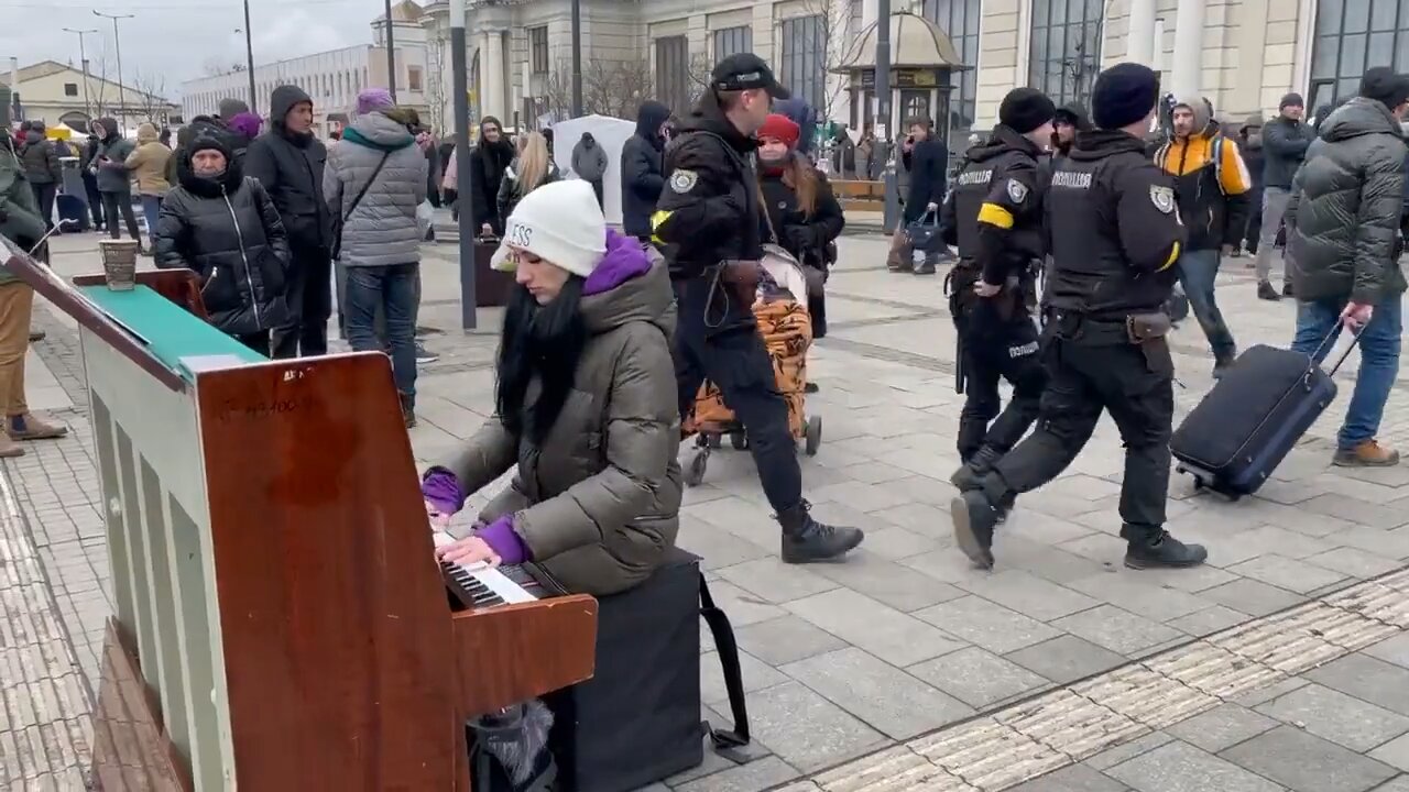 Lviv station, filled with exhausted refugees fleeing war as pianist plays “What a Wonderful World.”