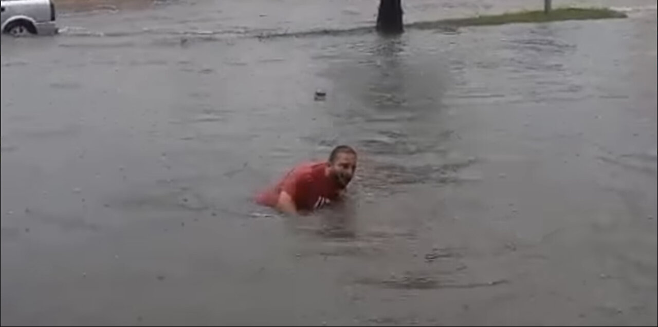 Unbelievable. A man swimming in the street after the flood