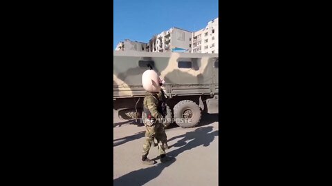 Russian soldier wears a funny costume head depicting a stereotypical Ukrainian