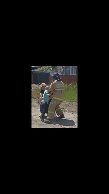 A child is rescued from a burning house in Makeevka after it was hit by a Ukrainian Grad MLRS