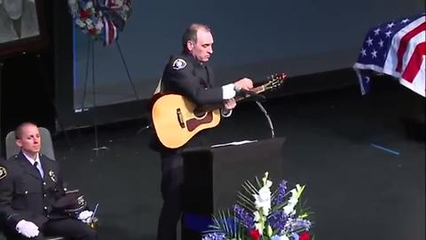 Fr. Tim Plavac performs an original song at the public funeral service for Officer Mathew Mazany