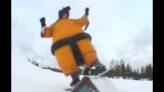 Professionelle snowboardere står på snowboard i sumodragter!