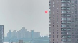 Complete red sun rises over New York City