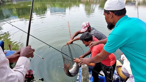 Young man catching big rohu fish