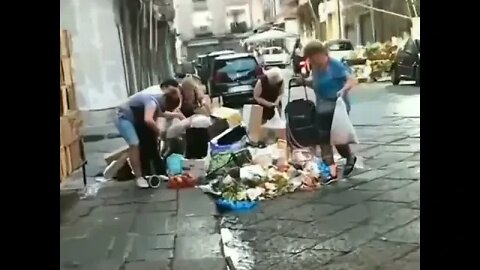 Italian women rummage through the leftovers of the market in search of food.