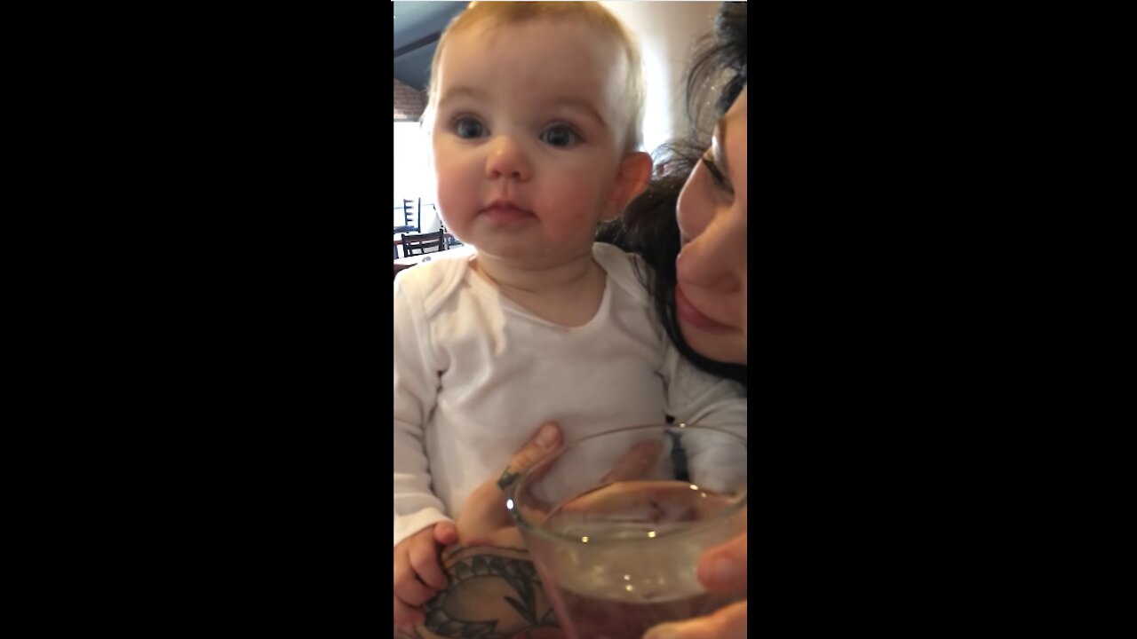 Adorable little girl first time drinking cold water.