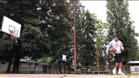 Jovem encesta bola de basquetebol de forma incrível