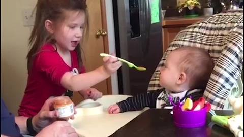 Toddler Girl Shows Her Father How To Feed The Baby