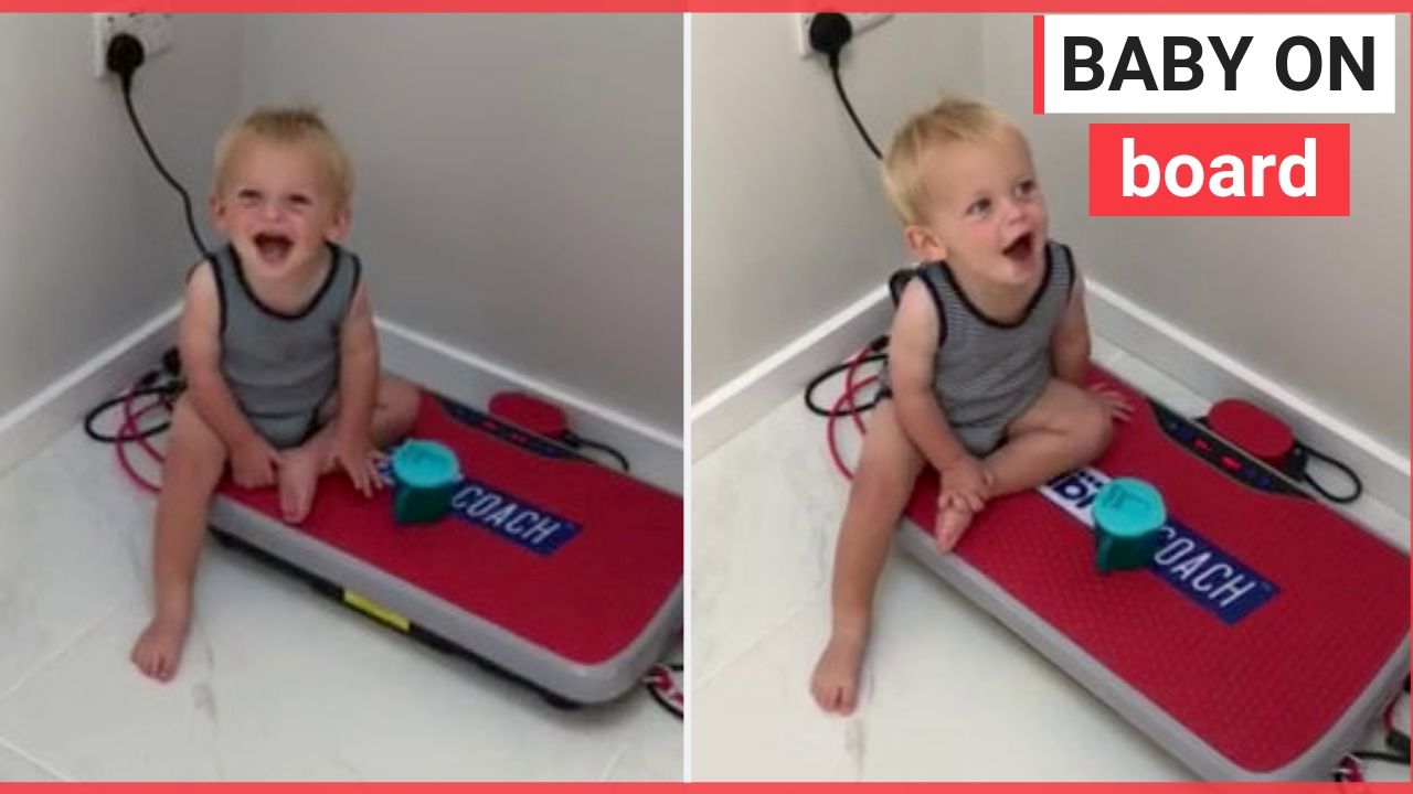 Toddler giggles as he sits on exercise board