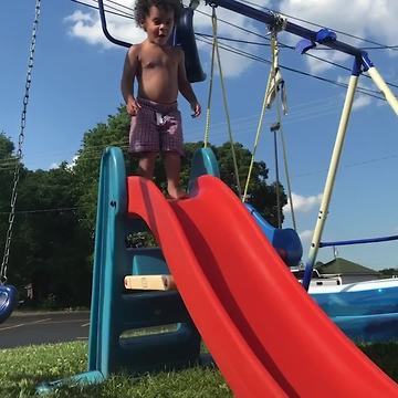 A Tot Boy Jumps Off A Slide