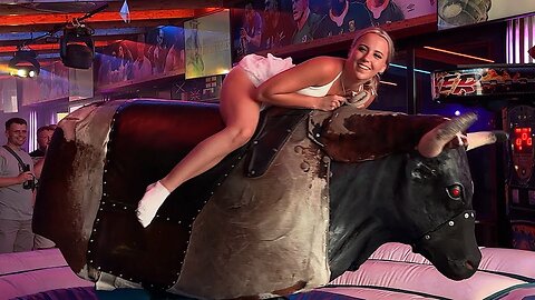 Benidorm Bull Ride_ Girl Rides Mechanical Bull in White Dress