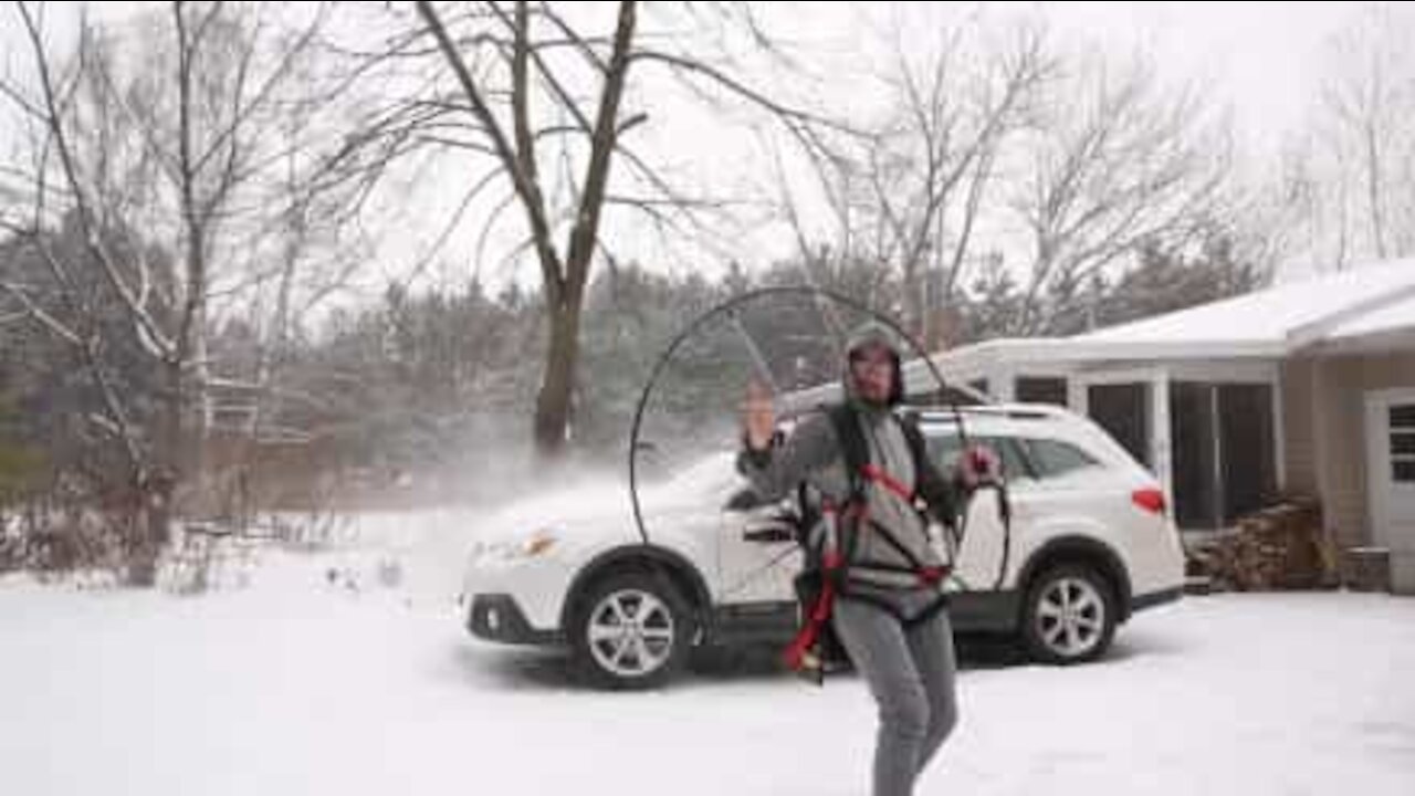 Man uses paramotor to blow snow from car