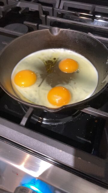 Frying eggs on pan with olive oil