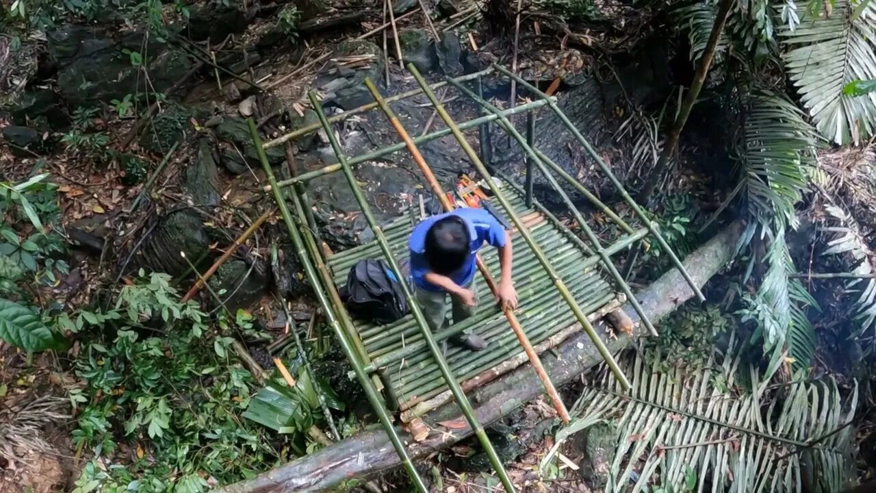 Building a bamboo shelter on a rock face:19
