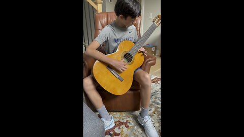 Grandson learning classical guitar