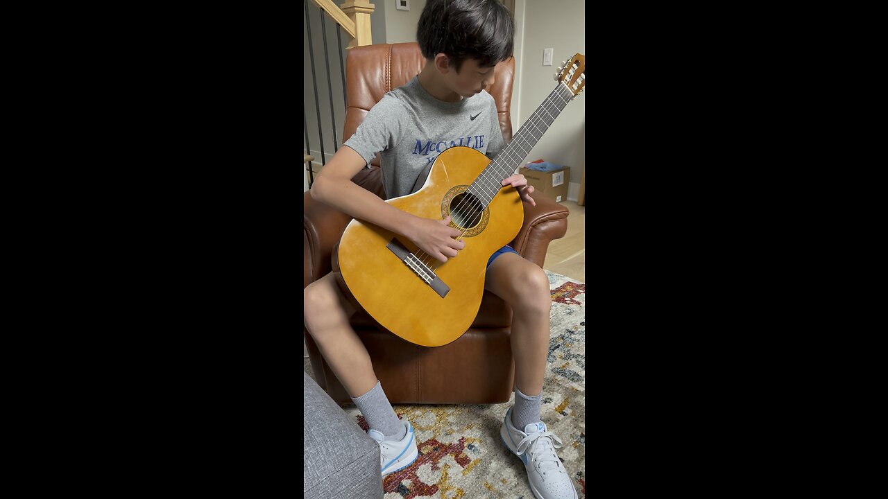 Grandson learning classical guitar