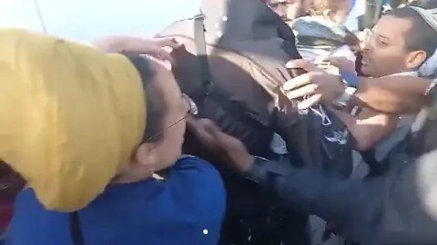 תיעוד מזעזע שוטר חובט בפניו של מפגין שמחזיק בבנו הקטן