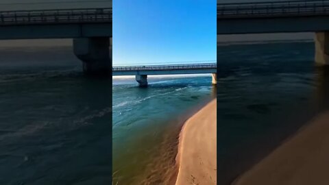 Crystal blue water by a bridge
