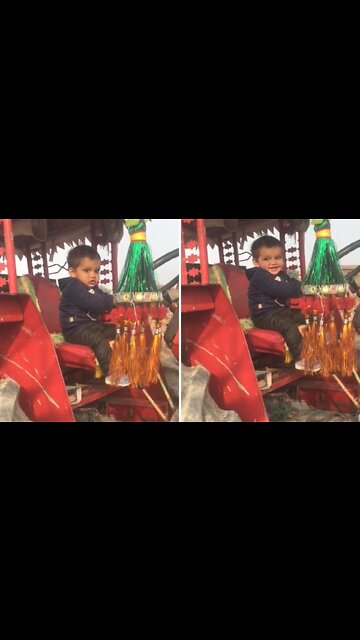 Baby preciously plays with his adorable agricultural tractor