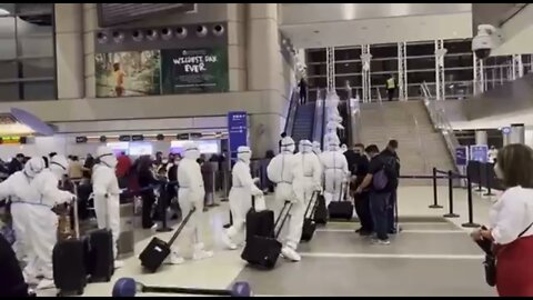 Chinese Guohang Airlines staff walk through LAX airport in America in protective suits