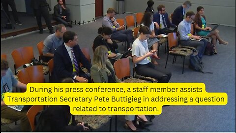 During his press conference, a staff member assists Transportation Secretary Pete Buttigieg