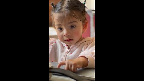 A young girl is smiling while holding a toy