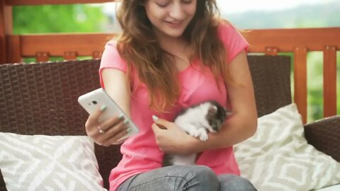 Girl playing with kitty and trying to do selfie with him