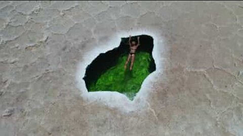 Woman swims in natural pool in the middle of the desert