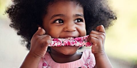 Cute baby showing how tasty noodles can be