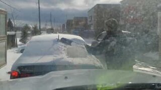 Homem gentil decide limpar a neve do carro à sua frente