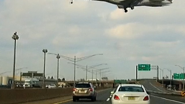 Spectacular dashcam view as jet crosses busy highway