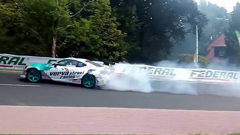 Drifting race car sends tire flying into the crowd