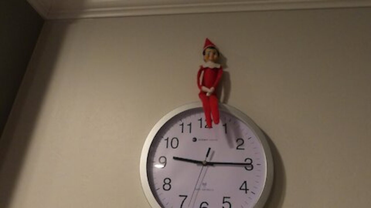 Elf on the Shelf sits on Clock