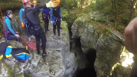 Man falls into the water in a canyon.