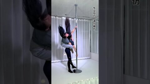 Two Chinese Girls Hang Upside Down On A Pole Together