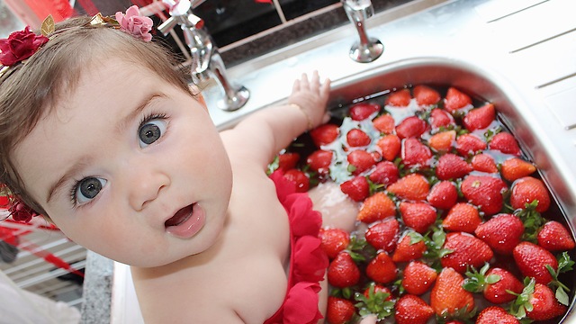 baby eating strawberry