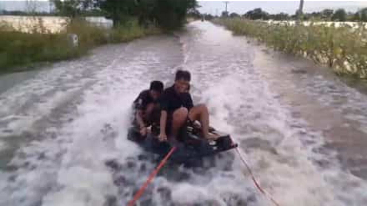 Wakeboarding på en oversvømmet vej i Thailand