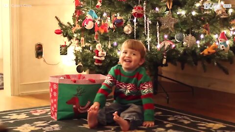 Un petit garçon est ravi de recevoir des fruits et des légumes à Noël