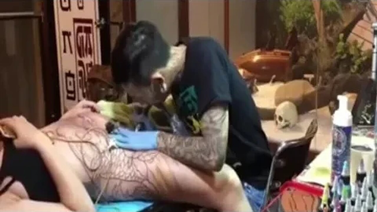 Girl having full body tatto in Thai tattoo parlour