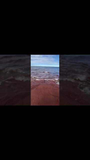 Waves crashing on red sand