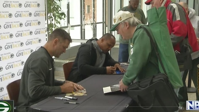 Featured alumni sign autographs at Lambeau Field