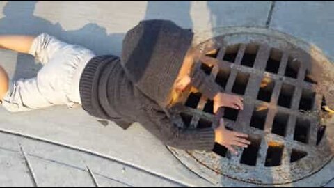 2-year-old girl talks into a sewer