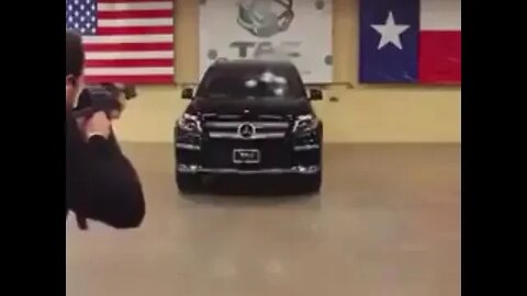 A man sits inside a Mercedes-Benz to take the gun shots in his bullet proof car