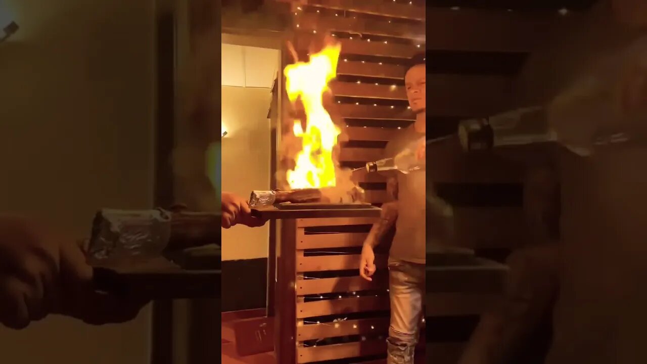 Tomahawk Steak Served Flaming on a Volcanic Rock at the Base of an Active Volcano